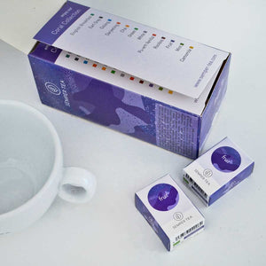 Caja abierta de Semper Tea Frutal mostrando bolsitas individuales y una taza blanca.