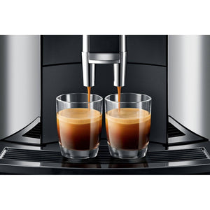 Detalle de la Jura WE8 Chrome sirviendo dos cafés espresso simultáneamente.