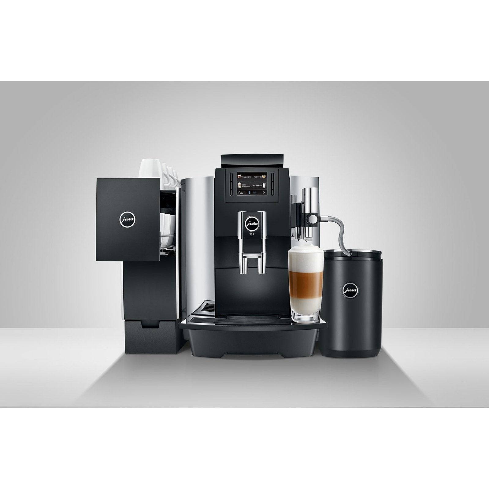 Jura WE8 Chrome con accesorios y una taza de café latte listo para servir.
